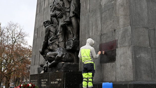 Ein Arbeiter reinigt das beschmierte Mahnmal in Warschau. (Bild: AFP/Sergei Gapon)