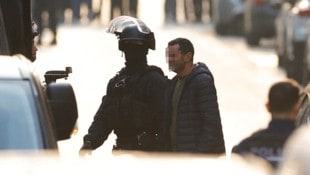 Die Polizei mit einer befreiten Geisel in Frankreich (Bild: AFP/Ian Langsdon)