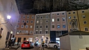 Mitten in der Lokalmeile sucht die Feuerwehr am Samstagabend die Felswand am Anton-Neumayr-Platz nach möglichen losen Steinen ab.  (Bild: zVg)