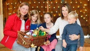 Caritas-Präsidentin Nora Tödtling-Musenbichler, Helena, Gioia, Barbara Stöckl und Simon (v. l. n. r.) befüllen einen Korb mit verschiedenen Sachspenden für die Aktion. (Bild: Holl Reinhard/Reinhard Holl)