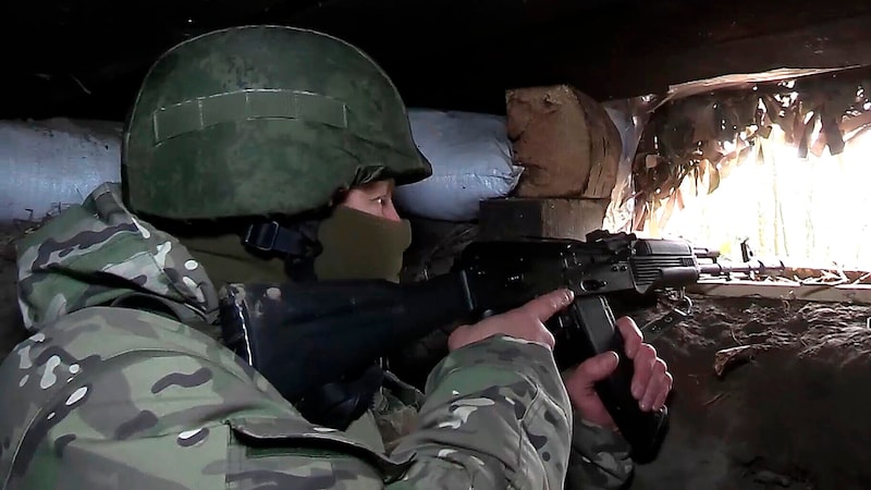 Ein russische Soldat beobachtet Bewegungen der ukrainischen Truppen in der Grenzregion Kursk von einem Bunker aus. (Bild: APA/AP)