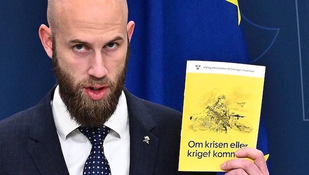 Schwedens Zivilschutzminister Carl-Oskar Bohlin mit einem Exemplar von „Wenn eine Krise oder ein Krieg kommt“ (Bild: APA/AP)