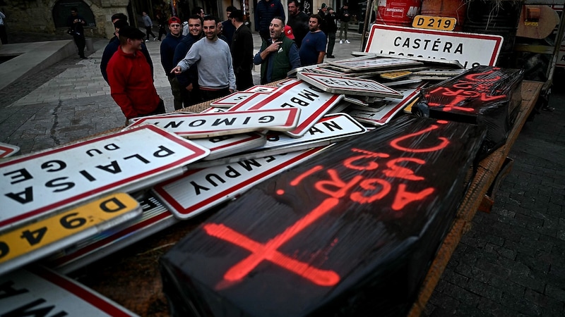 Local signs and coffins on a trailer are intended to draw attention to the death of farmers in many regions of France. (Bild: APA/AFP/Lionel BONAVENTURE)