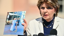 Gloria Allred, Anwältin der Familie von Halyna Hutchins, hält ein Foto von Hutchins  hoch, auf dem sie ihren Sohn Andros im Arm hält, während sie neben ihrer Mutter Olga Solovey steht. (Bild: APA Pool/Getty Images via AFP/GETTY IMAGES/Sam Wasson)