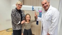 Noemi mit Mama Bianka und dem Chef der Kinder- und Jugendchirurgie, Holger Till vor dem Roboter. (Bild: Christa Blümel)