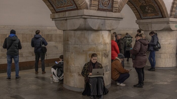A woman seeking shelter in the Kiev subway continues to work on her laptop.