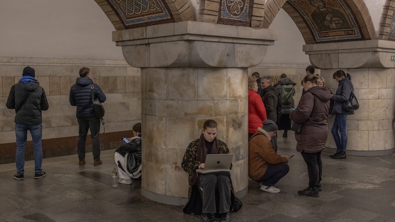 Eine Frau, die in der U-Bahn von Kiew Schutz sucht, arbeitet an ihrem Laptop weiter. (Bild: APA/AFP )