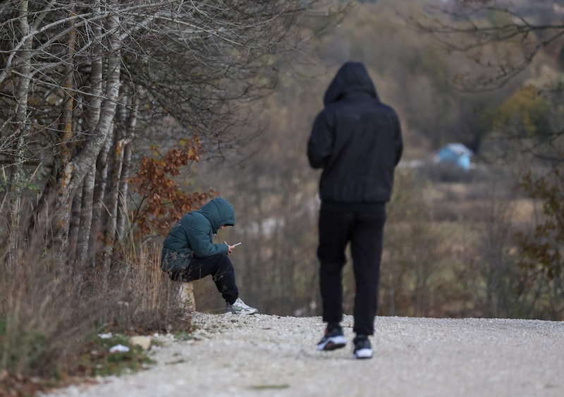 Migranten außerhalb des Camps (Bild: AFP )