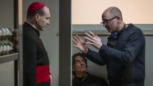 „Konklave“-Regisseur Edward Berger bespricht mit Hauptdarsteller Ralph Fiennes Szenenbilder. (Bild: Constantin Film)