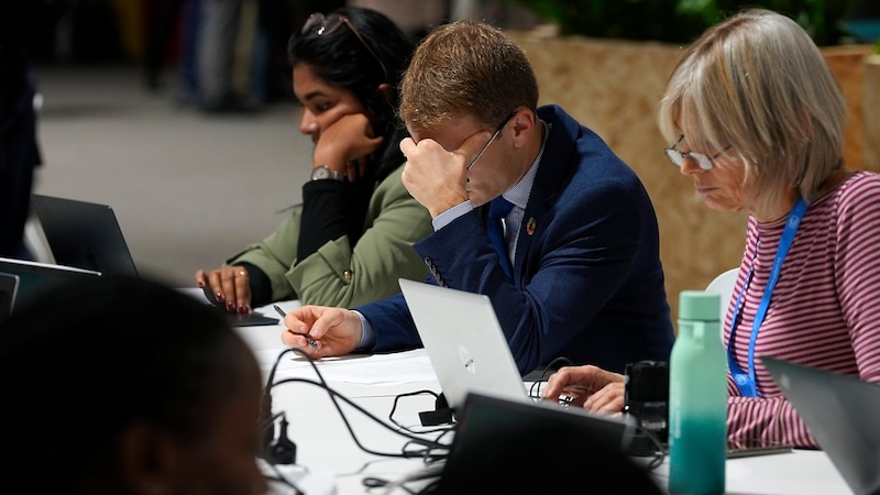 Delegationsmitglieder studieren die jüngsten Vorschläge. An eine Beschlussfassung zum geplanten Ende der Konferenz war nicht zu denken. (Bild: APA/AP)