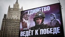 Auf dem Propaganda-Plakat vor dem russischen Außenministerium steht: „Die Einheit führt zum Sieg“. (Bild: APA/AFP/Alexander NEMENOV)