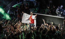 Ski Aggu im Empire St. Martin mit dem Banner eines Fans als Umhang.
