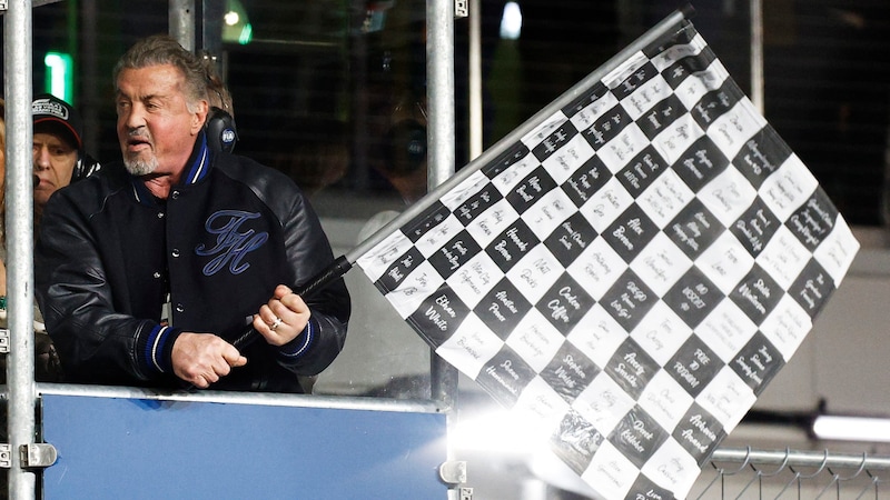 Sylvester Stallone waved the chequered flag, visibly excited. (Bild: APA/Getty Images via AFP/GETTY IMAGES/Chris Graythen)