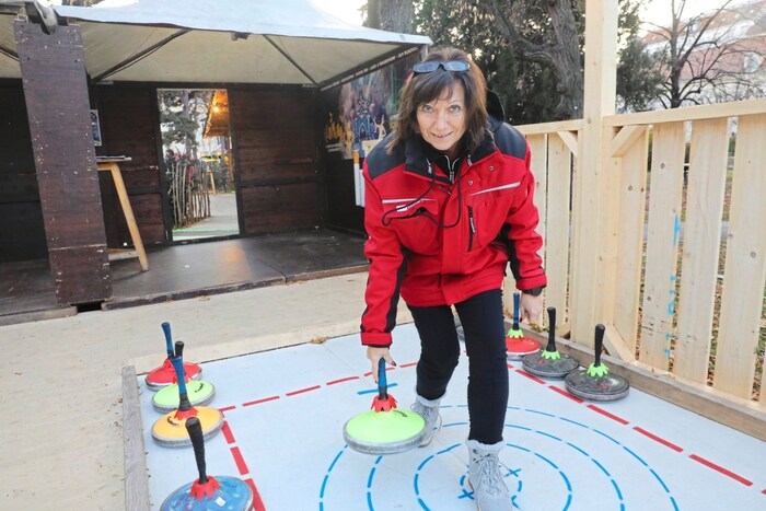 Mitarbeiter führen in die Kunst des Eisstockschießens ein.