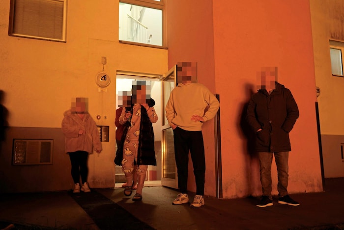 Bewohner blicken erschüttert auf das Inferno vor ihrem Haus. 
