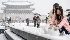 Schneemann-Bauen mitten im Zentrum von Seoul. (Bild: APA/AFP/ANTHONY WALLACE)