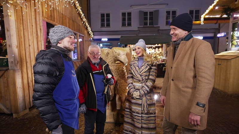 Silvia Schneider und Armin Assinger am Villacher Adventsmarkt mit den Holzschnitzern Mark Puntel und Renato Puntel (Vater) . (Bild: ORF)