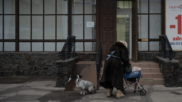 Eine Ukrainerin vor einer der letzten geöffneten Apotheken