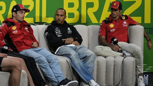 Lewis Hamilton (m.) schnappte Carlos Sainz (r.) das Auto weg, fährt bald im Ferrari-Team um Charles Leclerc (li.) um Punkte. (Bild: APA/AFP/Nelson ALMEIDA)