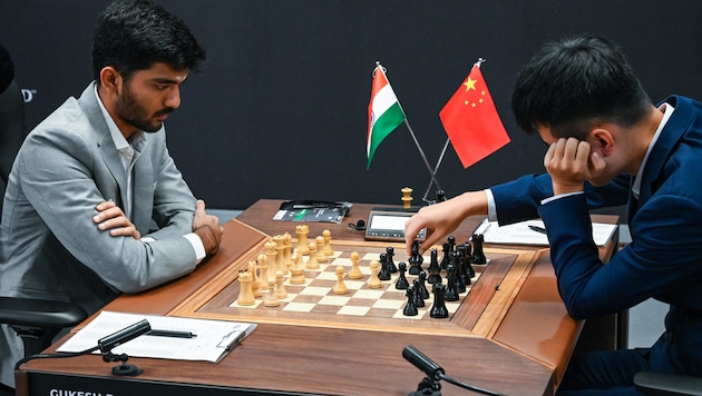 Ding Liren (re.) und Dommaraju Gukesh duellieren sich im Schach.  (Bild: APA/AFP/Roslan RAHMAN)