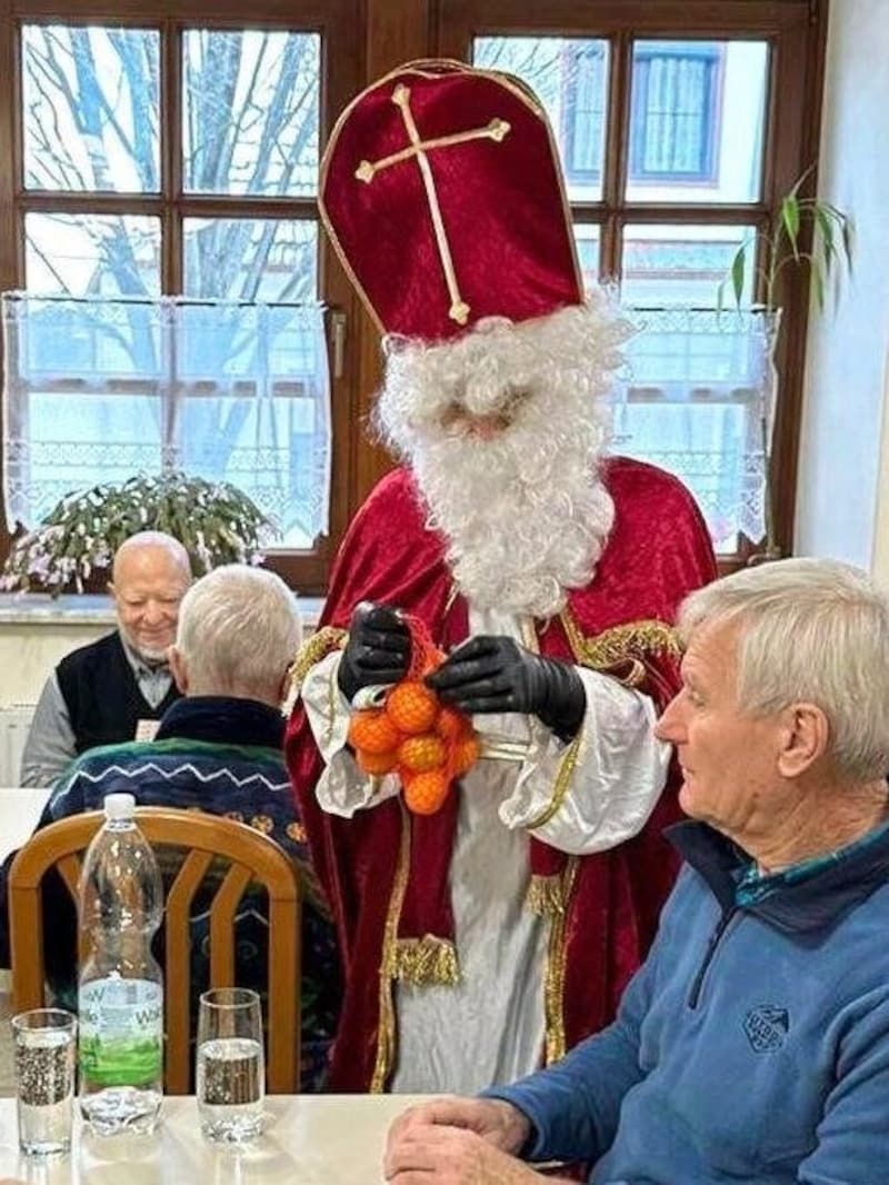 Bürgermeisterin Bettina Zentgraf mit weißem Bart und in roter Bischofsrobe beschenkt Pensionisten in Mörbisch. (Bild: Privat)