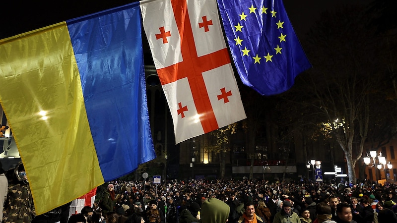 Die ukrainische Flagge als Erinnerung an die ukrainischen Maidan-Proteste und die EU-Flagge als Ziel der georgischen Revolte  (Bild: APA/AFP/Giorgi ARJEVANIDZE)