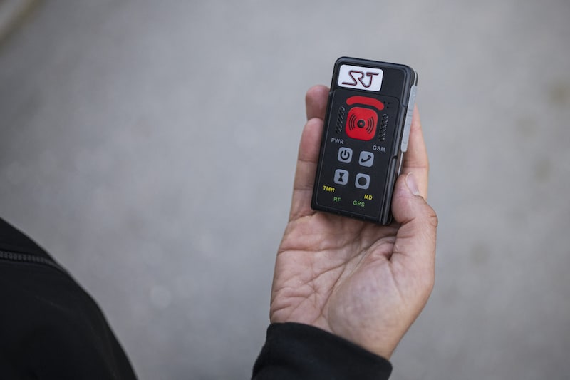 In Örebro, volunteers canvass the streets of disadvantaged neighborhoods in the evenings and warn young people of the danger of falling into the clutches of the gangs. One of the social workers shows off his emergency device, which transmits an SOS as soon as he presses the red button. (Bild: AFP)