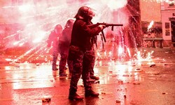 Demonstranten schießen Feuerwerkskörper auf Polizisten, die Tränengas abfeuern.