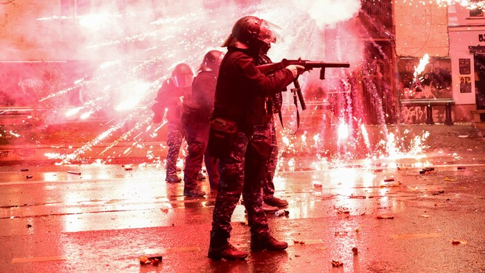 Demonstranten schießen Feuerwerkskörper auf Polizisten, die Tränengas abfeuern.