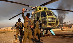 Rebellen posieren für ein Selfie vor einem in Aleppo erbeuteten Armeehubschrauber.