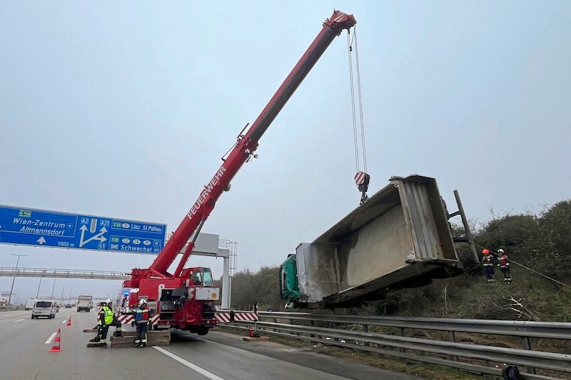 Der tonnenschwere Lkw wurde mit dem Feuerwehrkran über die Leitschiene gehievt. (Bild: FF Wiener Neudorf)