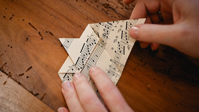 . Das Stück, das ganz zu Beginn gefaltet wurde, nach außen hin öffnen und falten, dabei leicht ...