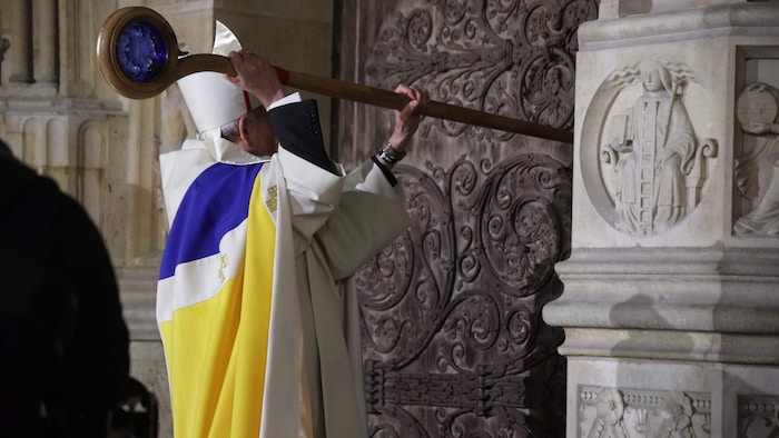 The Archbishop of Paris, Laurent Ulrich, knocked on the gate with his staff.