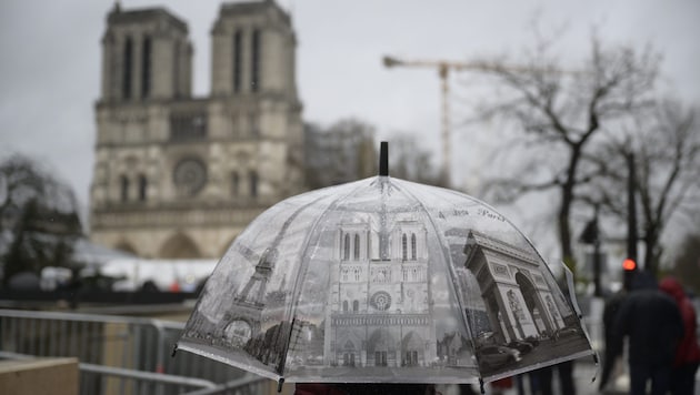 Some die-hard fans braved the rain in Paris on Sunday morning to watch the inauguration mass of Notre-Dame (Bild: Imre Antal)