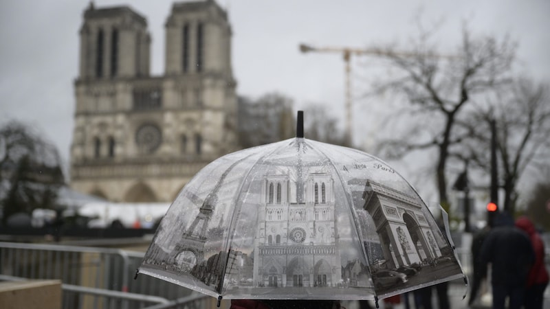 A few hardy fans braved the rain in Paris on Sunday morning to watch the Notre-Dame inauguration mass. (Bild: Imre Antal)