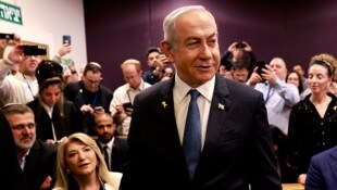 Premier Benjamin Netanyahu mit einem Lächeln bei seiner Ankunft im Gerichtssaal (Bild: APA/AP)