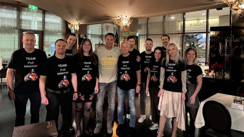 Prof. Mittermair (center) was surprised by his surgeons with a shirt message at the Christmas party. (Bild: zVg)