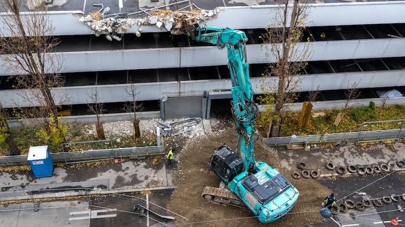 The demolition work on the parking garage has begun - with a worker in a yellow high-visibility vest right underneath falling building material. (Bild: AUVA / Veronika Drda)