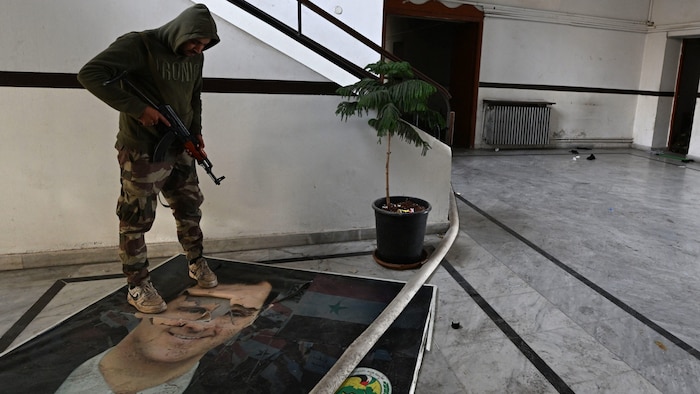 A rebel fighter literally tramples a portrait of ousted President Bachar al-Assad underfoot.