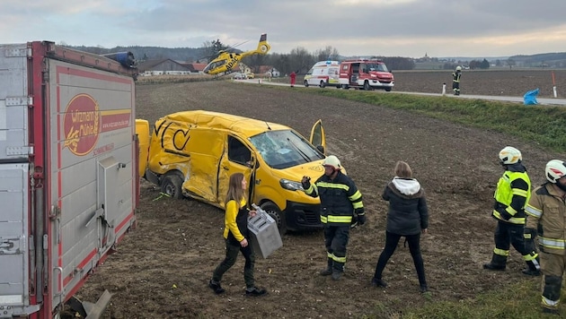 Der Postwagen wurde beim Unfall in Mörschwang völlig demoliert – im Hintergrund hebt der Rettungsheli in Richtung Spital ab  (Bild: Scharinger Daniel/Daniel Scharinger)