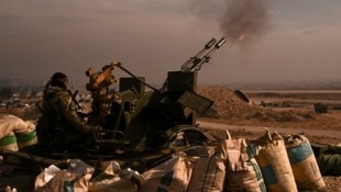 Ein Rebellenkämpfer feuert mit einer Flugabwehrkanone auf den Militärflughafen Mazzeh außerhalb von Damaskus. (Bild: APA/AFP/Aris MESSINIS)