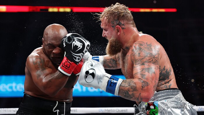 Mike Tyson gets into the ring against Jake Paul (r.).