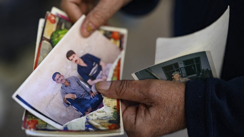 Er zeigt Journalistinnen und Journalisten alte Fotos. (Bild: AFP/Yasin Akgul)