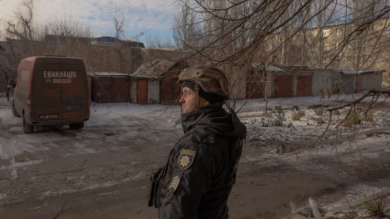 Ein ukrainischer Polizist bei der Evakuierung von Zivilisten aus Pokrowsk (Bild: APA/AFP/Roman PILIPEY)