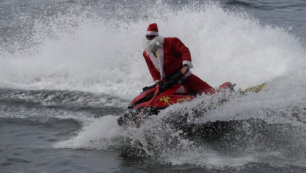 Weihnachtsmann ohne Rentierkutsche, dafür auf spritzigen Jetski in Rio e Janeiro. Der verkleidete Feuerwehrmann rettete ganz nebenbei ein paar Wassersportler. (Bild: Associated Press)