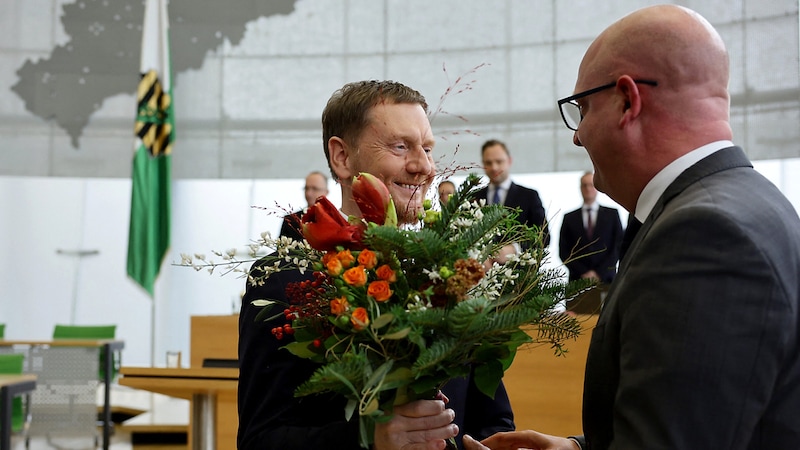 Der obligatorische Blumenstrauß für den neuen alten Ministerpräsidenten (Bild: APA/AFP/Jens Schlueter)