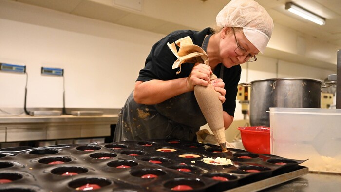 Der Teig wird in der DoN-Backstube in die Silikonmatte gespritzt.