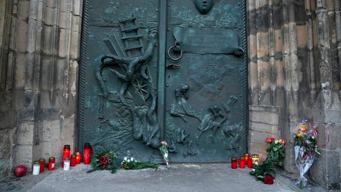 Blumen und Kerzen werden vor der St.-Johannes-Kirche in der Nähe des Weihnachtsmarktes ...
