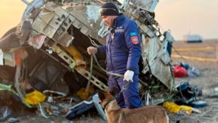 Ein Helfer neben dem Wrack des abgestürzten Flugzeugs in Aserbaidschan (Bild: AP/Kazakhstan's Emergency Ministry Press Service)