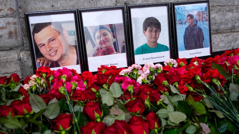 Blumen und Porträts zum Gedenken an die Opfer des Absturzes (Bild: ASSOCIATED PRESS)